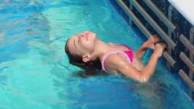 küçük kız tube havuz kenarında tarafından tutar ve suya daldırır