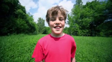 küçük çocuk çim glade ile bulutlar mavi gökyüzünün altında yürüyor