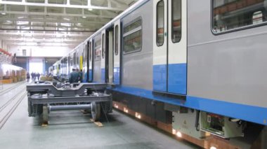 New gray carriages of train stand in assembly shop of plant