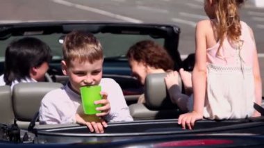 Çocuklar ebeveynleri ile oturup cabriolet ve çocuk içecekler