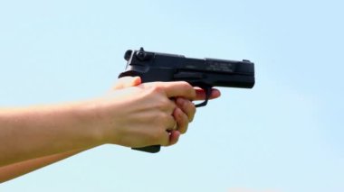Alyans parmak tutan silah ve ateş etmek ile kadının el