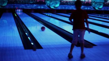 Küçük çocuk atar bowling topu ve atlar