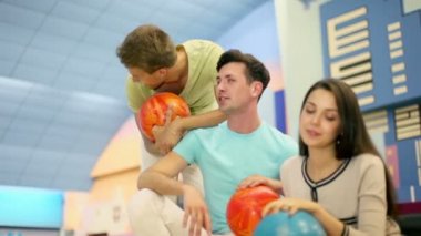 Üç öğrenci erkek kızla oturup bowling kulüpte konuşmak