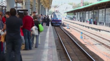 birçok kişi bir tren istasyonu platformu üzerinde bekleyin.