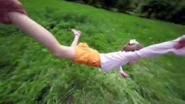 el kızı onun el ve ayak tutar, o çim uçar