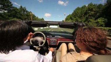 Erkek ve kadın tarafından asfalt yol ağaçları arasında cabriolet binmek
