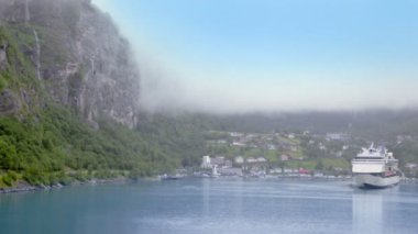 Buz dağ altında kıyı köy yakınındaki büyük liner ile