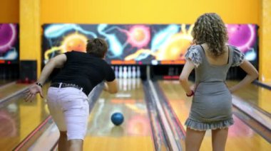 Boy cips, kız çok mutlu atlar yenmek için bowling topu atar