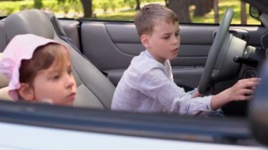 İki çocuk erkek ve kız yaz gününde cabriolet oturmak