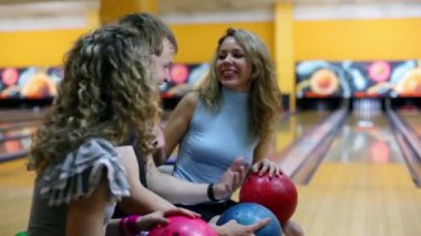 Kız bir adamla konuşmak ve lane Bovling, arka plan gülümsemek