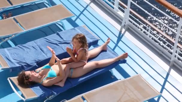 Mutter und Tochter spielen in okie dokey liegend in Chaiselongue — Stockvideo