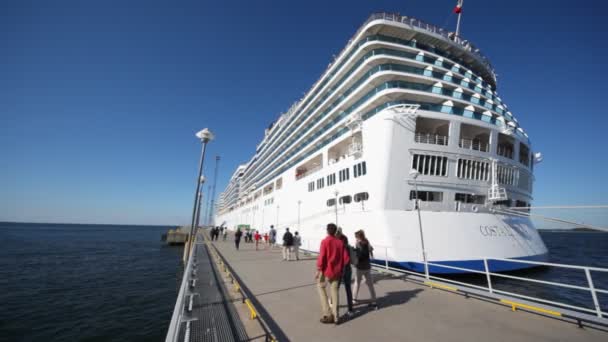 Riesiges Passagierschiff im Hafen und Menschen an Land — Stockvideo