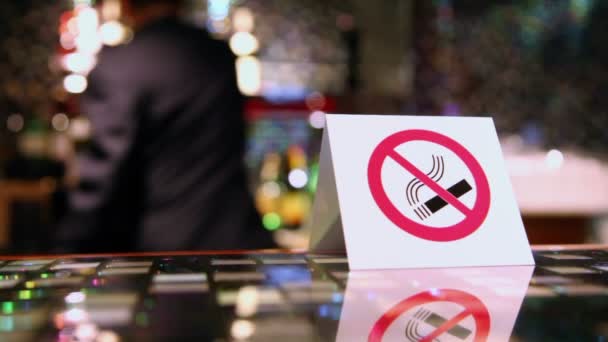 Символ отказа от курения на тарелке за столом и движение человека на заднем плане — стоковое видео