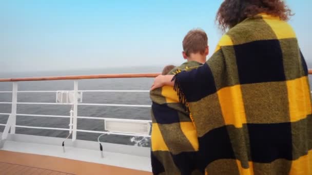 Mutter mit Kindern in Plaid eingewickelt stehen auf Deck in der Nähe von Zaun — Stockvideo