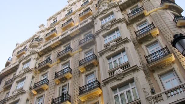 Altes Gebäude mit Balkonen steht vor blauem Himmel — Stockvideo