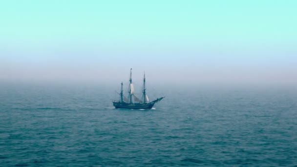 Voilier flotte par la surface ondulée de la mer loin sous le ciel bleu 