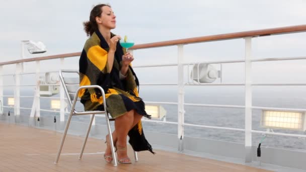 Femme avec cocktail assis par bateau près de bord et regarde de loin — Video