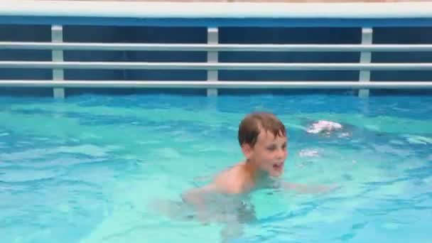 Chlapec plave v bazénu z nichž pára stoupá nahoru — Stock video