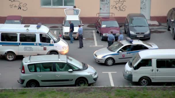 Trois policiers de deux voitures spéciales travaillent sur le parking — Video