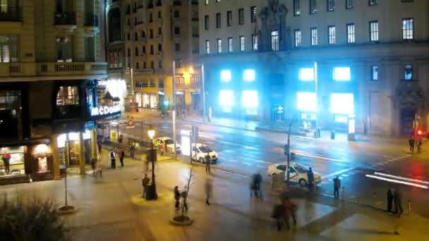 People walk on Gran Via Street near cafe of McDonald at night — Stock Video