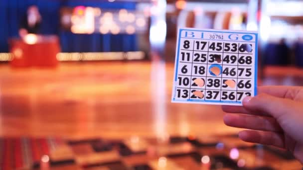 Ręka trzyma bilet do gry w bingo i lider deklaruje dane — Wideo stockowe