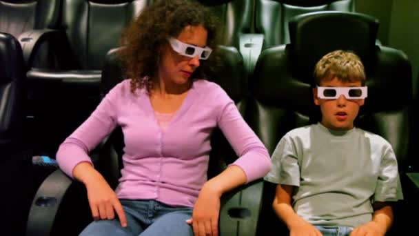 Mutter sitzt mit Sohn in 3D-Stereobrille im Kino — Stockvideo