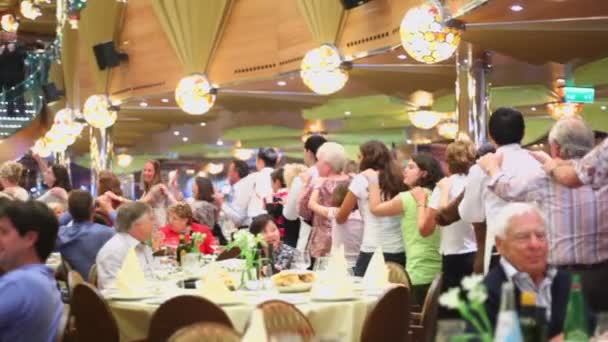 People dance among tables in restaurant on ship during cruise — Stock Video