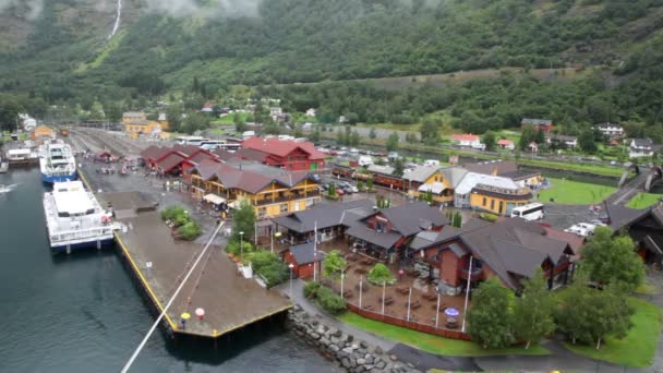 Personas que se mueven por debajo en un pequeño puerto entre casas en el valle del fiordo — Vídeos de Stock