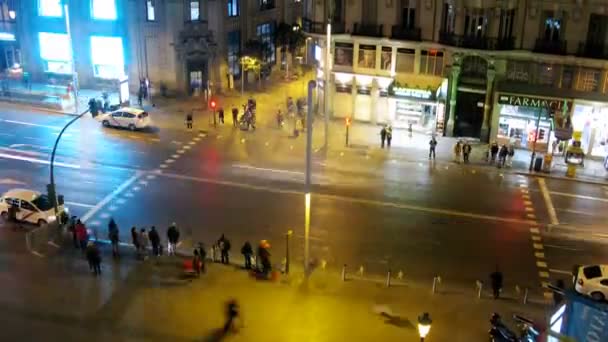 Pessoas cruzam a rua Gran Via na passarela à noite — Vídeo de Stock