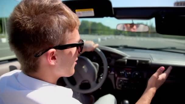 Student i solglasögon ride drive cabriolet av street — Stockvideo