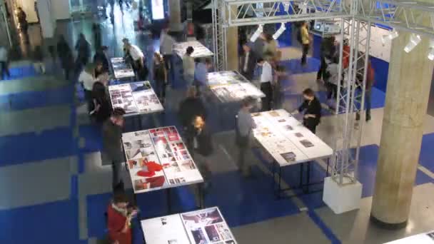 Los visitantes miran ideas arquitectónicas en imágenes en la exposición — Vídeos de Stock