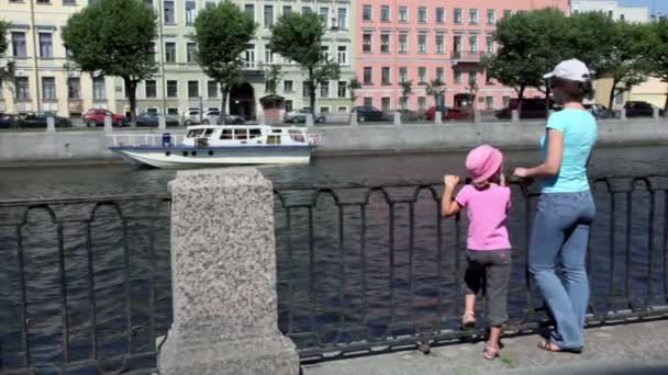 Vrouw staan met dochter aan kade in de buurt van hek — Stockvideo