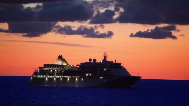 Navire avec flotteurs d'éclairage en mer au coucher du soleil sur ciel nuageux 