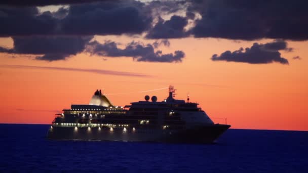 Nave con illuminazione galleggia in mare al tramonto su cielo nuvoloso — Video Stock