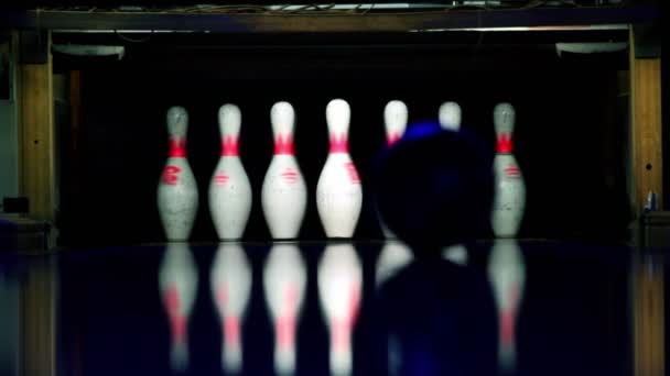 Rollos de bolas y golpea a los ninepins en el carril de bolos iluminado en la oscuridad — Vídeo de stock