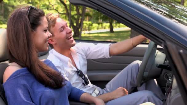 Boy and girl sit and laught in cabriolet at sunny summer day — Stock Video