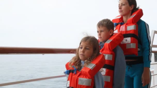 Moeder met dochter en zoon in reddingsvesten staat op het schip dek — Stockvideo