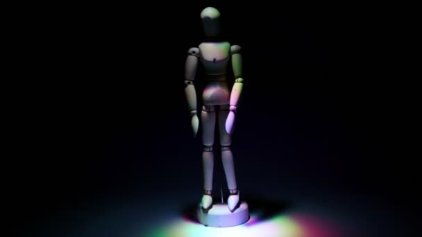 Дерев'яні іграшкові чоловіки, освітлені кольоровим світлом на темному фоні — стокове відео
