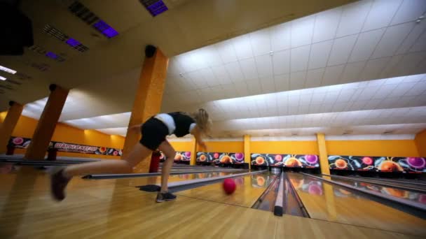 Dívka hází bowlingovou kouli a dělá strike od beaty všechny kuželky — Stock video