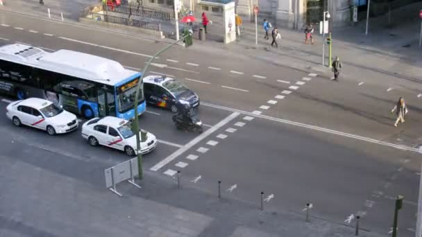 Orang-orang menyeberang jalan Gran Via di persimpangan jalan di pagi hari — Stok Video