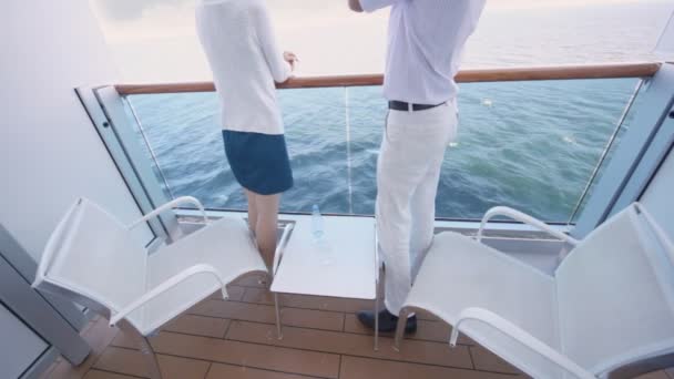 Man en vrouw kijken naar zee in omheind balkon van dek van schip — Stockvideo