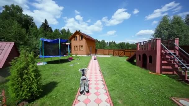 Parco giochi vicino sentiero attraverso cortile di casa di campagna — Video Stock