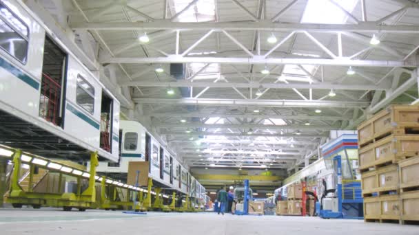 Trabajadores descargan cargadoras en taller de planta de ingeniería — Vídeos de Stock