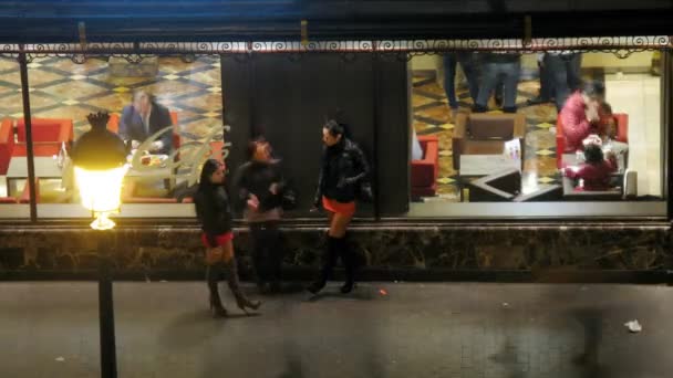 Tres chicas se paran cerca de la cafetería por la noche en Madrid — Vídeos de Stock