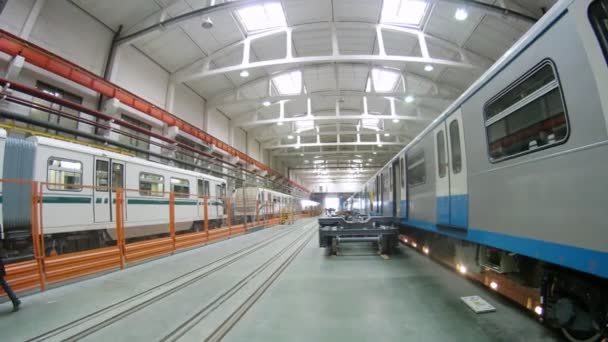 Два поезда стоят на платформе на машиностроительном заводе, время пошло — стоковое видео