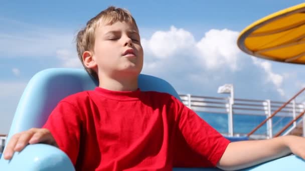 Chico duerme en chaise lounge en la cubierta del barco en tiempo soleado — Vídeos de Stock