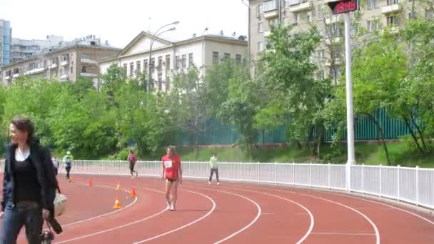Atletas corren en pista de carreras de estadio del centro olímpico — Vídeo de stock