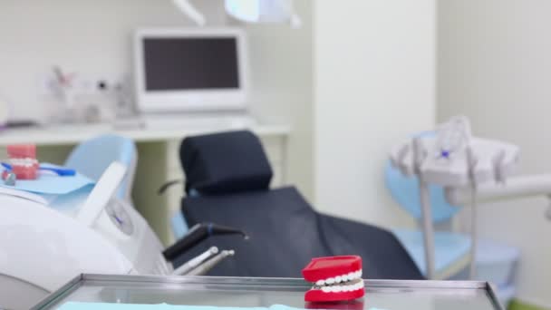 Duża zabawka szczęki zaskoczy jego zęby na stole w chirurgii stomatologicznej — Wideo stockowe