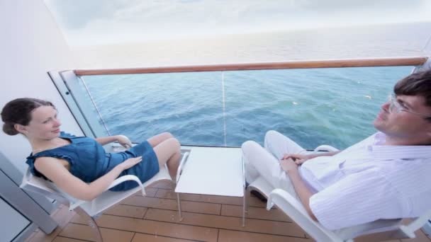 Mujer y el hombre se sientan parte vallada de la cubierta de la nave mirar el agua — Vídeos de Stock