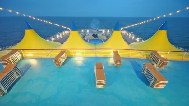 Deckchairs near pool and tents on deck of ship — Stock Video